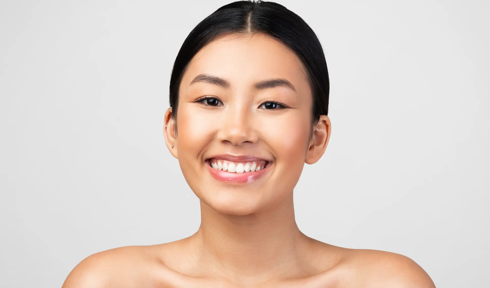 Pretty-Korean-Young-Woman-Smiling-Posing-Shirtless-Over-Gray-Background.webp