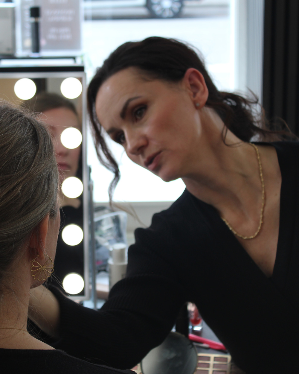 Hår & makeup artist lægger makeup på en kunde i salonen på Frederiksberg
